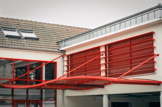 View of a building with a metallic wavy red porch