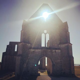 An abandoned church with the sun in place of the bell tower