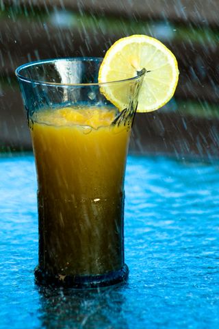 Cocktail with an orange slice under the rain