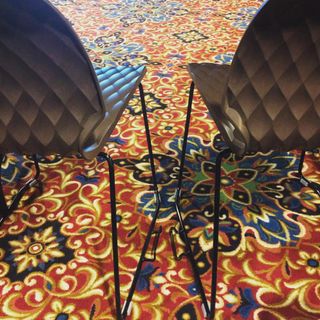 Two chairs on a very colorful and complex carpet