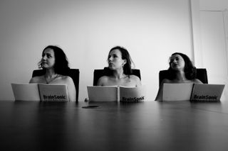 Three nude woman in a meeting room listening to the speaker with attention